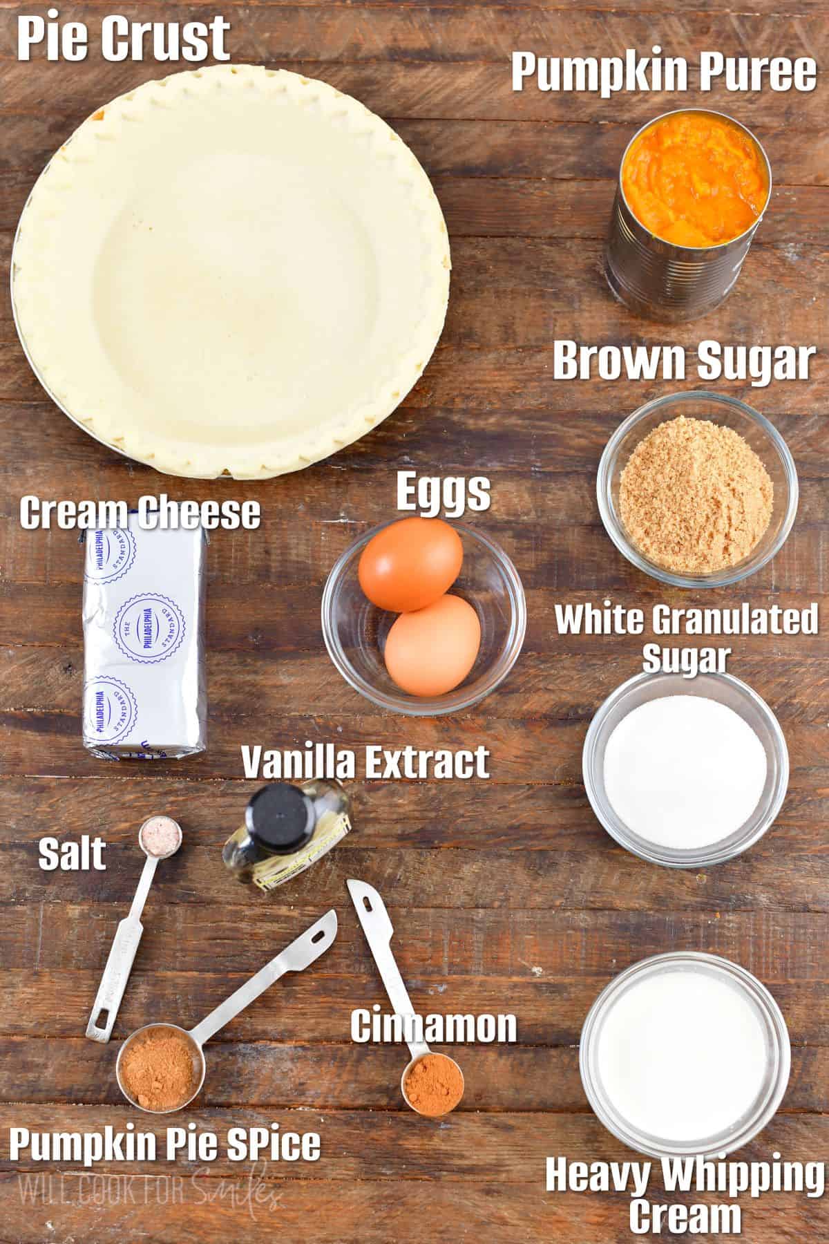 ingredients to make pumpkin cheesecake pie on a wooden board.