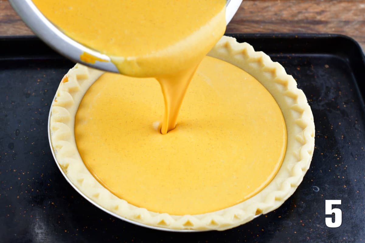 pouring the pumpkin cheesecake pie filling into the pie crust.