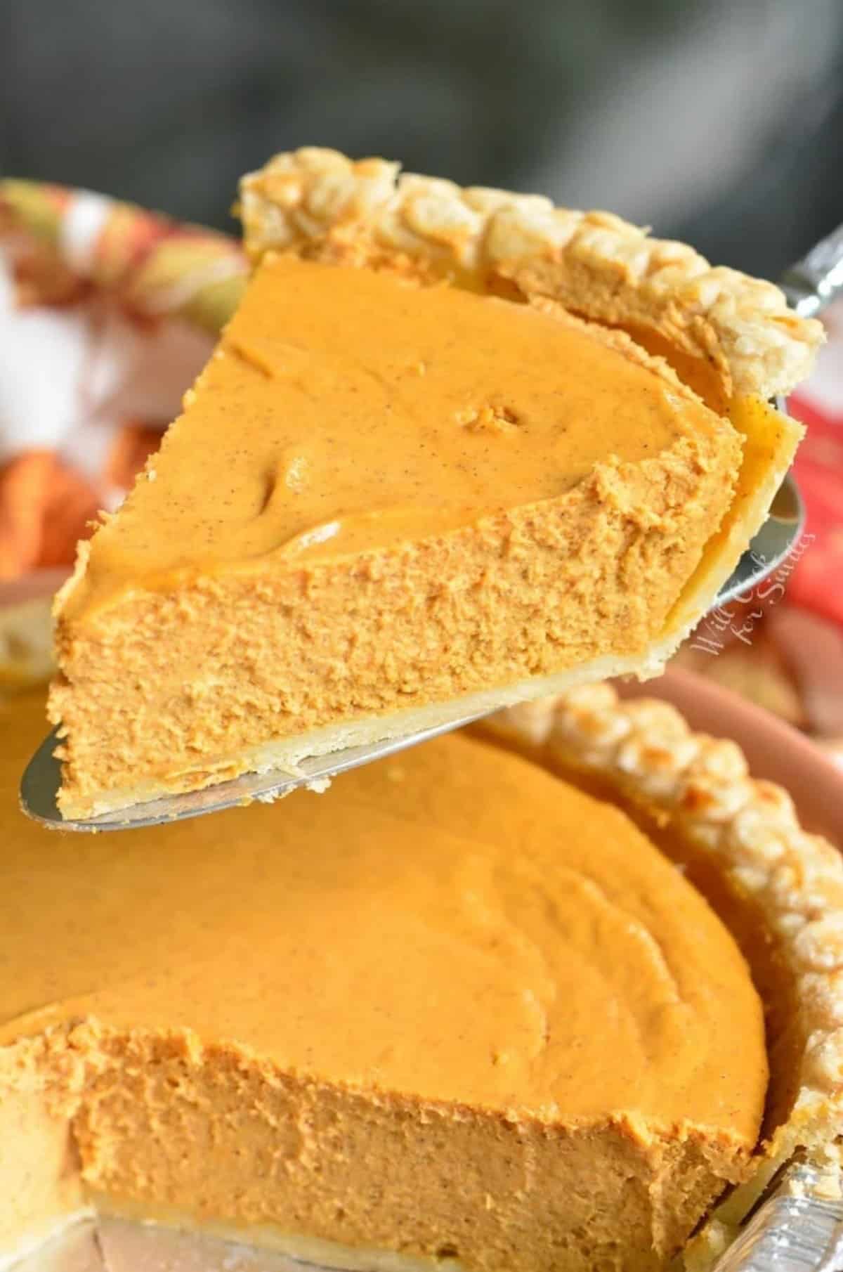 pulling a slice of pumpkin cheesecake pie out of the pan.