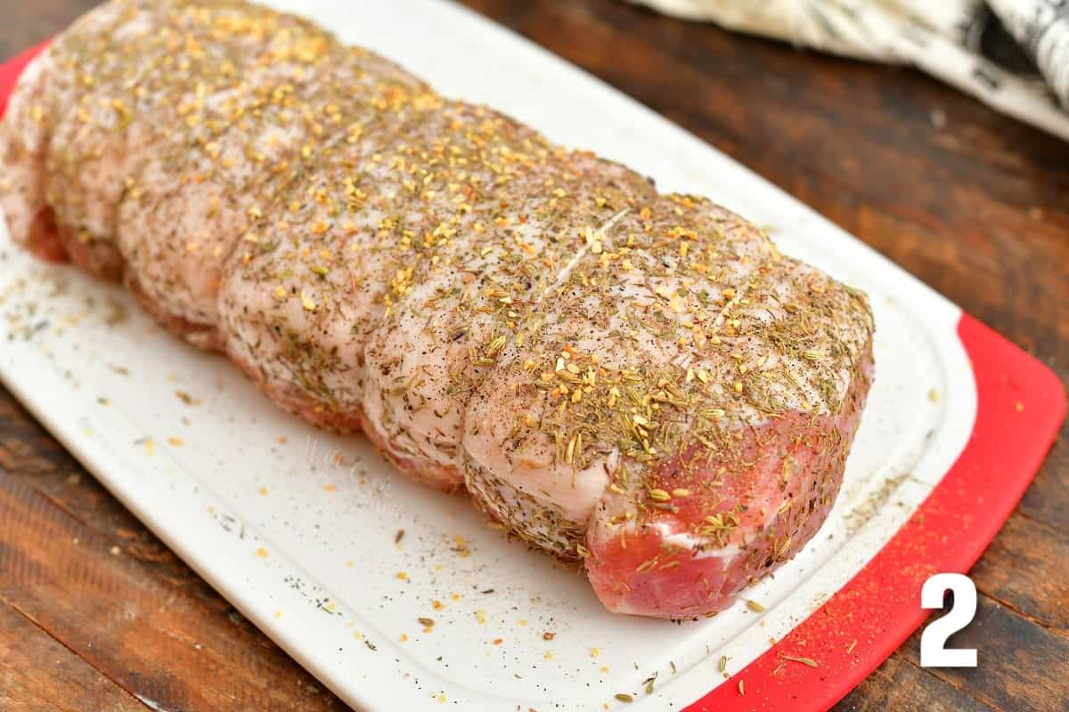 tied and seasoned pork loin on a cutting board.