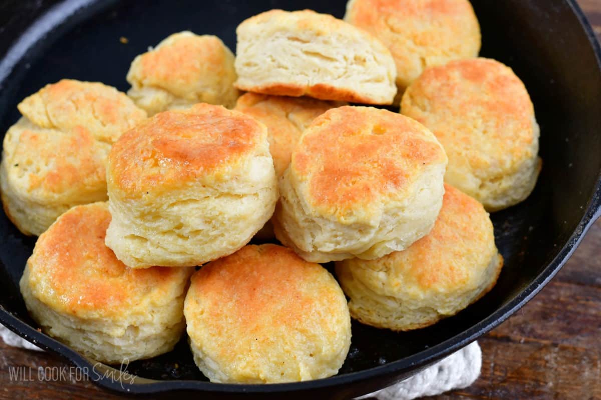 lots of biscuits stacked up in a skillet.