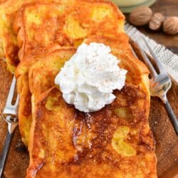 Eggnog French Toast on a plate with whipped cream on top.