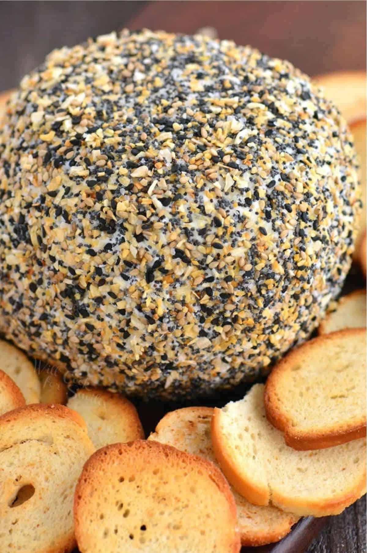 everything bagel seasoning coated cheese ball with some crispy bread.