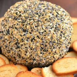 big round cheese ball coated in everything bagel seasoning with bread.