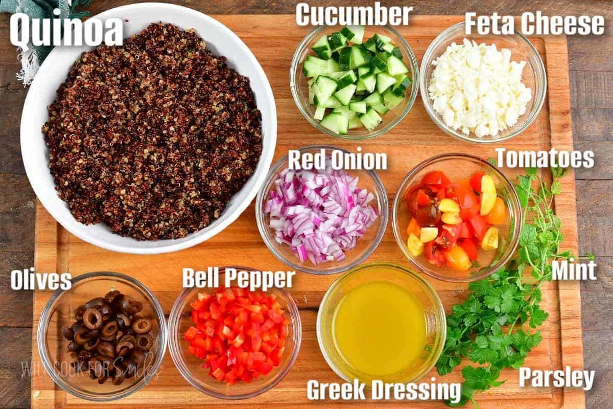 labeled ingredients to make Mediterranean quinoa salad on the cutting board.