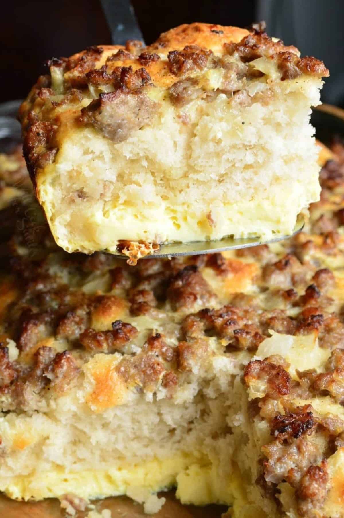 taking a piece of sausage breakfast casserole out of casserole dish with a spatula.