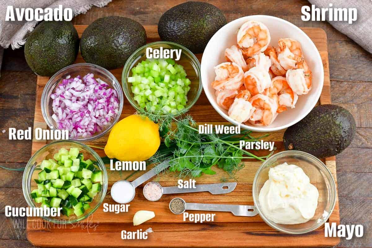 labeled ingredients to make shrimp salad stuffed avocadoes on the cutting board.