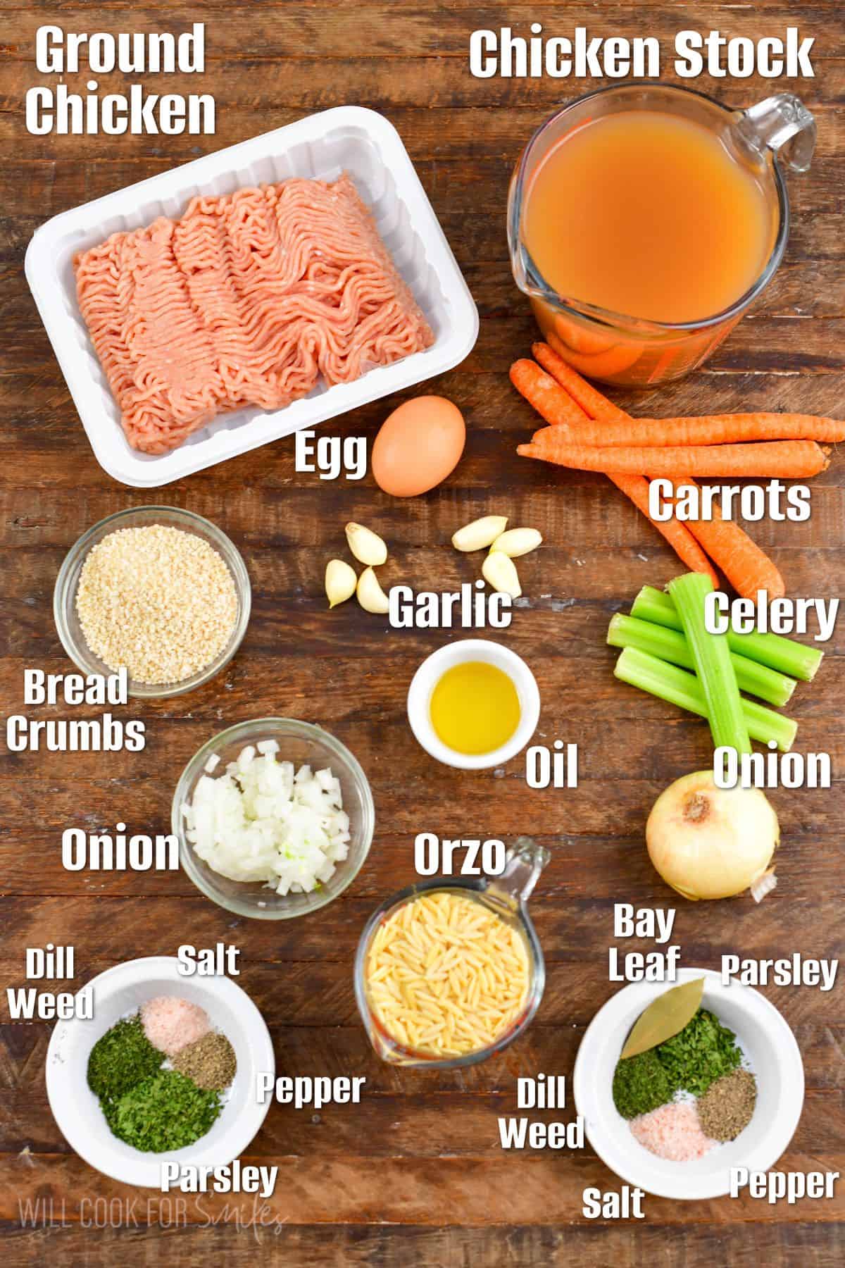 Labeled ingredients for chicken meatballs with orzo soup on a wood surface.