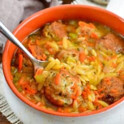 chicken meatball and orzo soup with a spoon scooping some out.