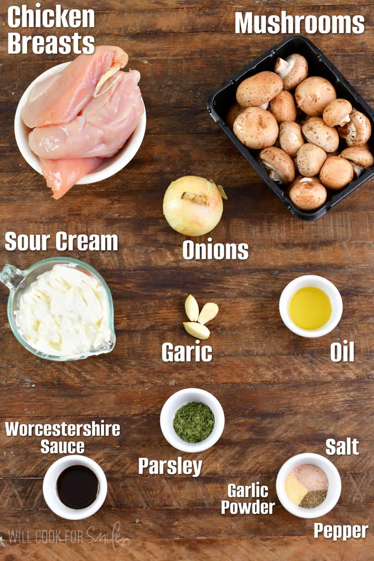 Labeled ingredients for chicken stroganoff on a wood surface.
