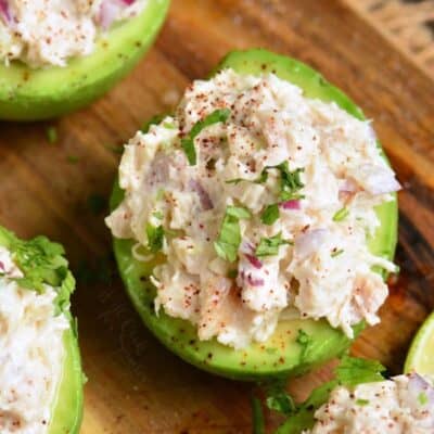 avocado half stuffed with chicken salad and some more surrounding it.