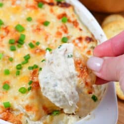 scooping out some hot baked crab dip with a bread cracker.