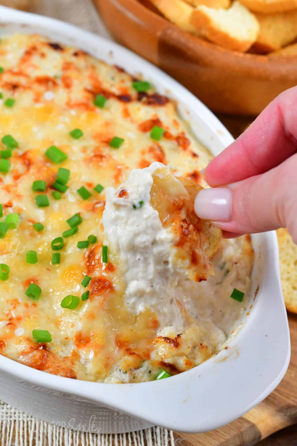 dipping into the hot crab dip with some bread crackers.