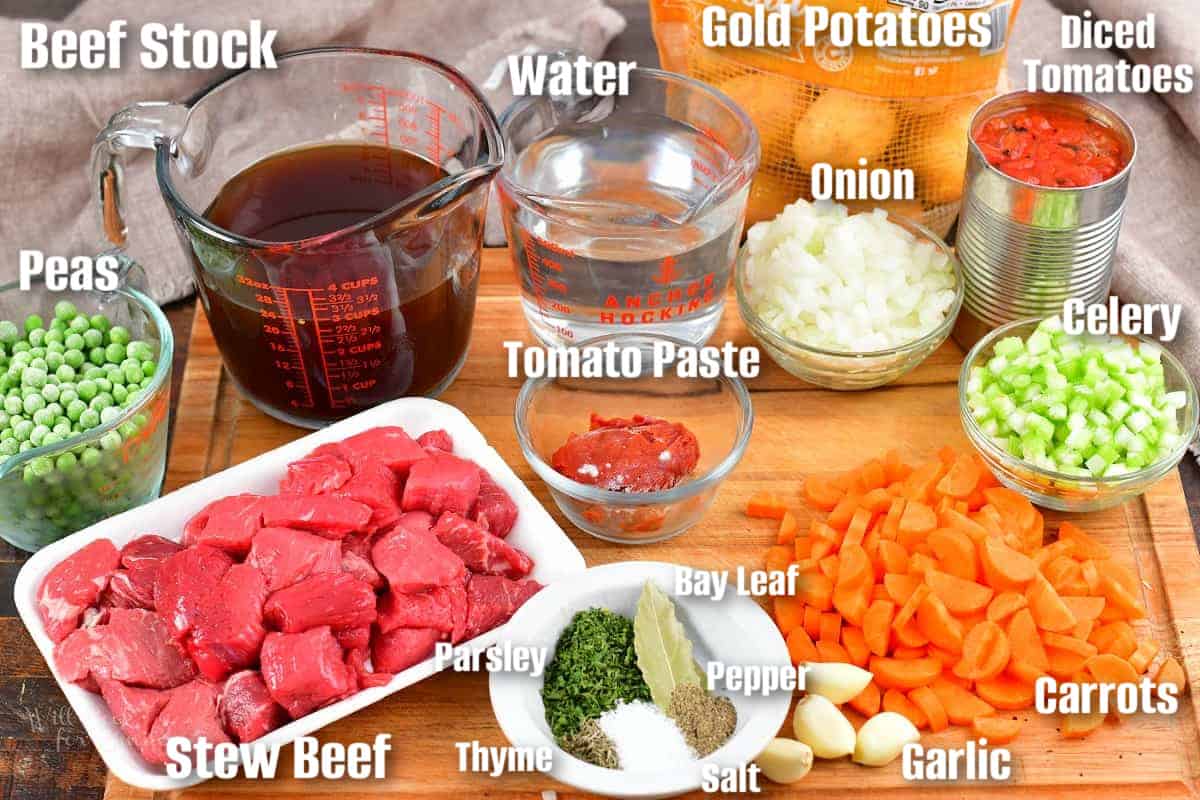 labeled ingredients for vegetable beef soup on a cutting board.