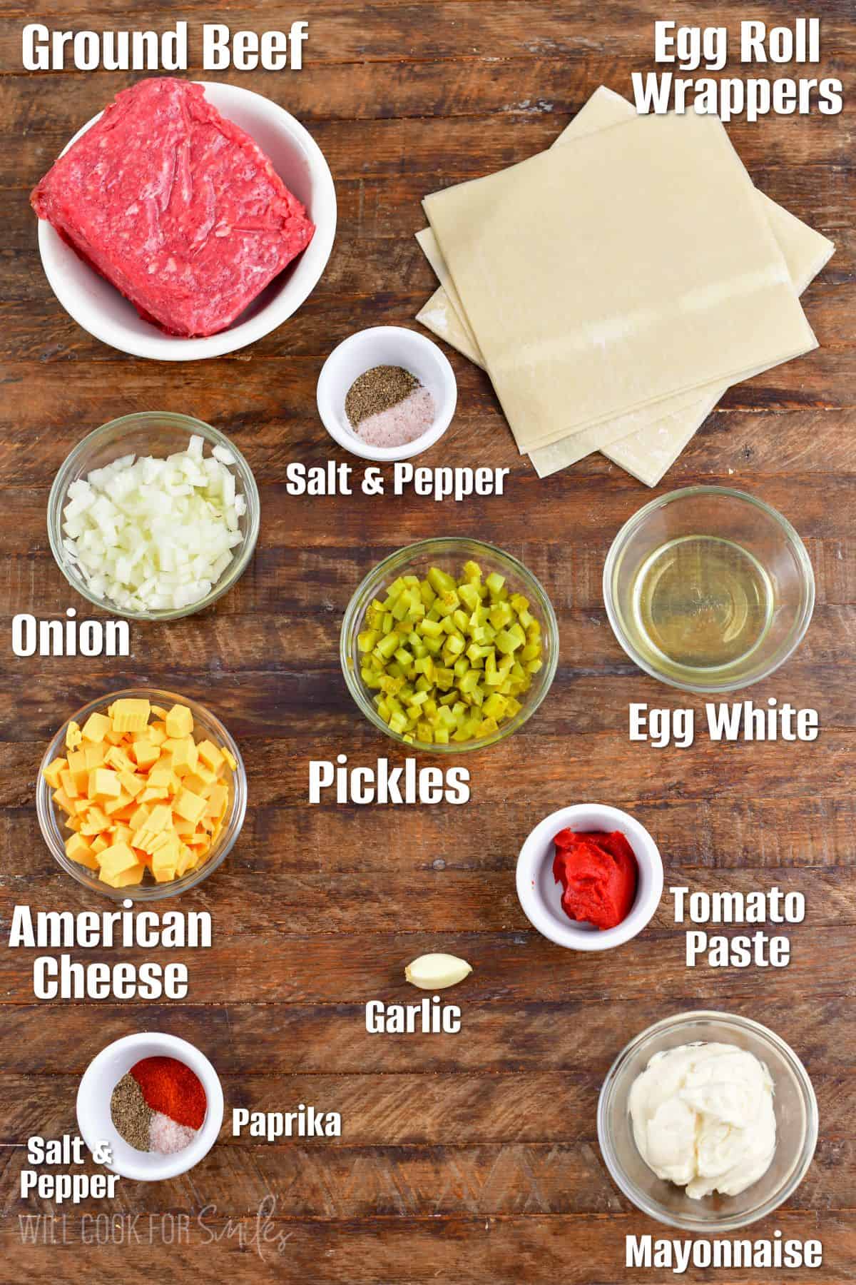 labeled ingredients to make cheeseburger egg rolls on wooden board.