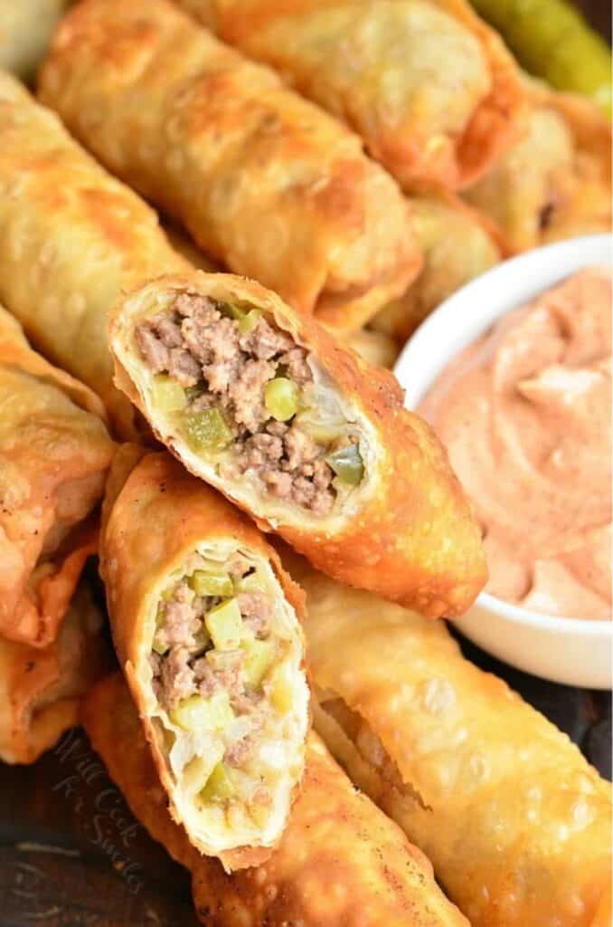 two cut halves of a cheeseburger egg roll on top of others side by side.