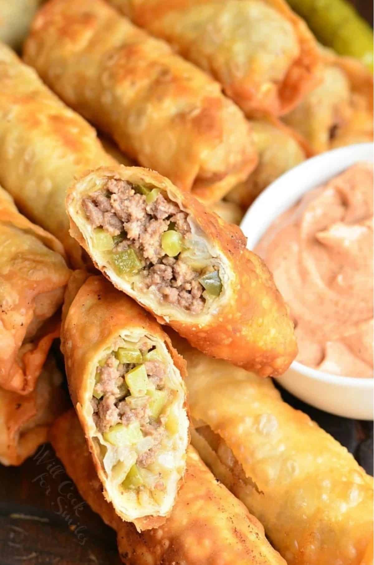 two cut halves of a cheeseburger egg roll on top of others side by side.