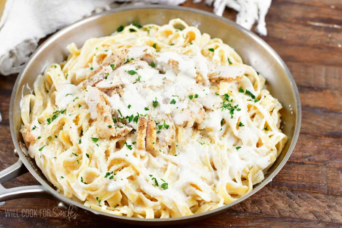 Chicken alfredo in a pain with parsley sprinkeled on top.
