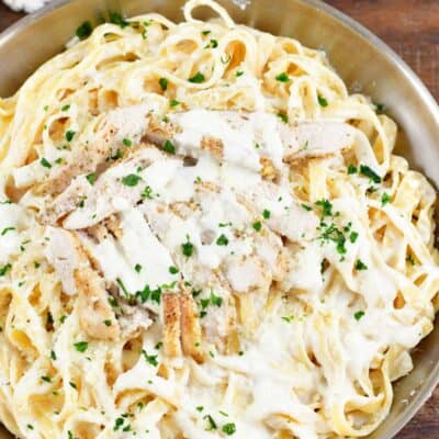 Chicken alfredo in the pan with sliced chicken on top.