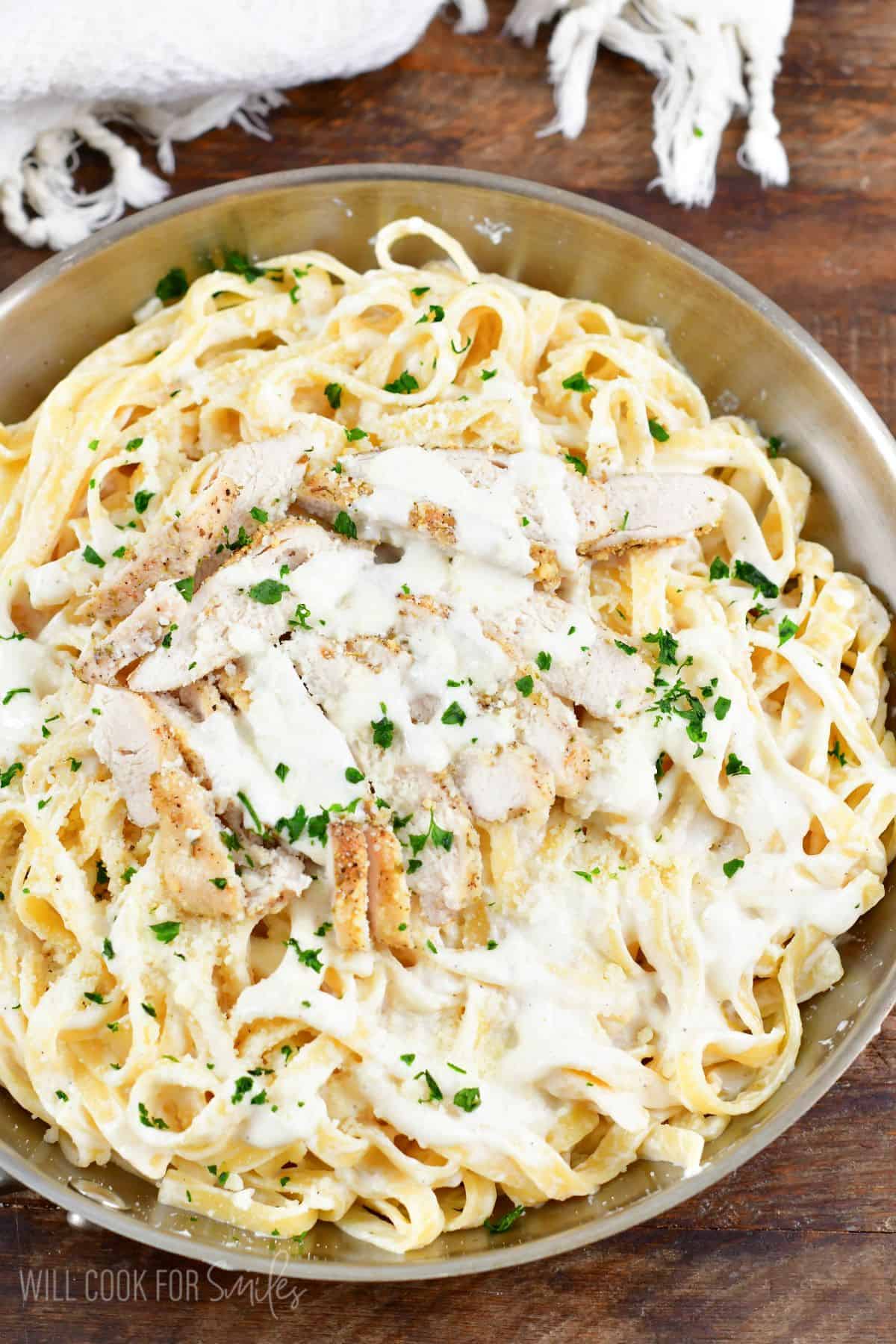 Chicken alfredo in the pan with sliced chicken on top.