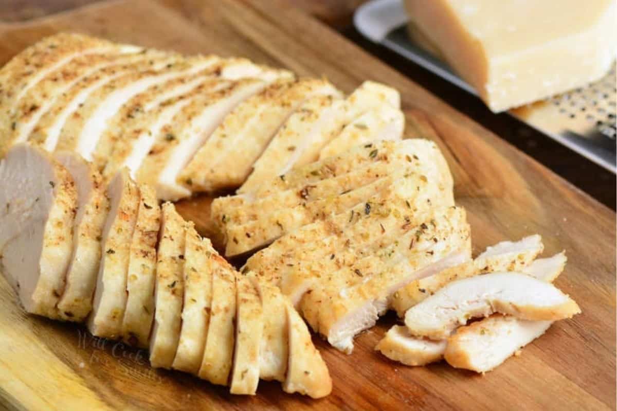 sliced chicken on a wood cutting board.