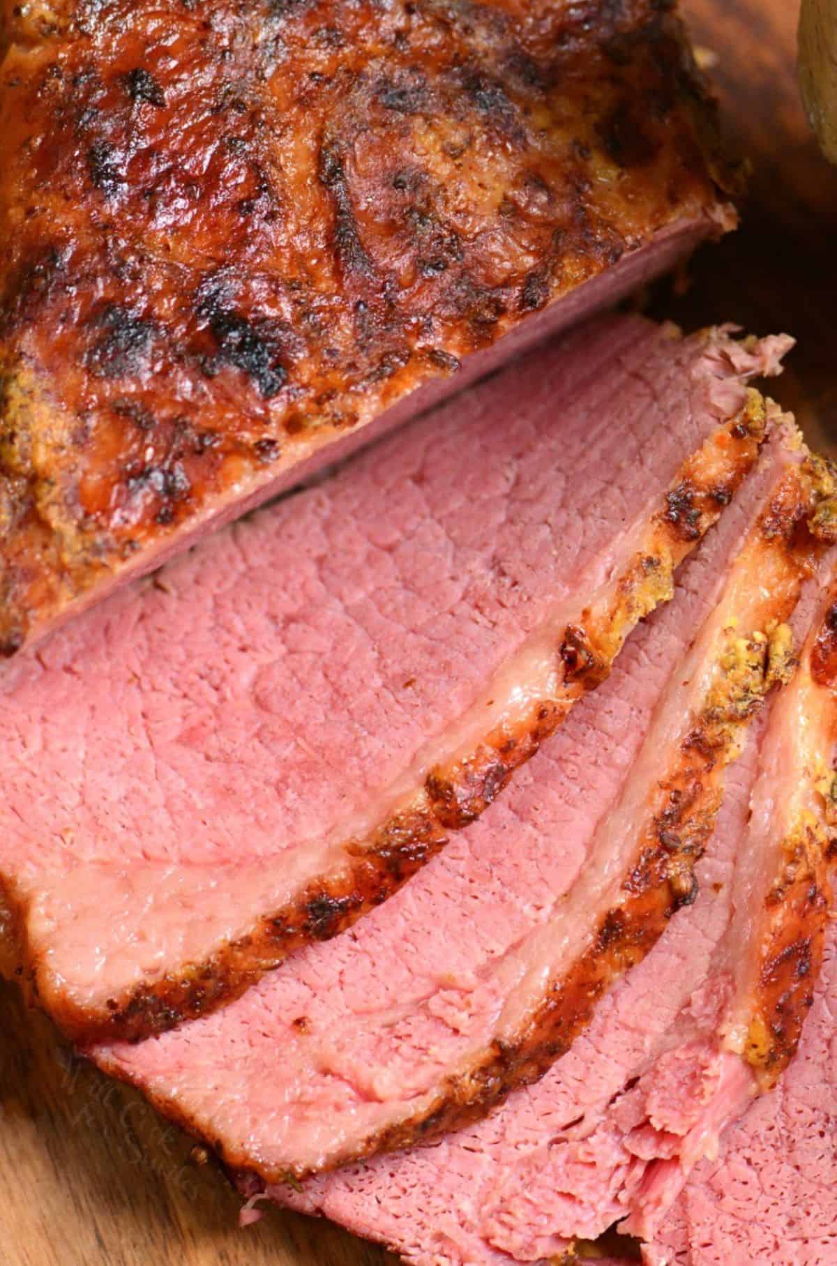 Corned beef sliced on a cutting board.