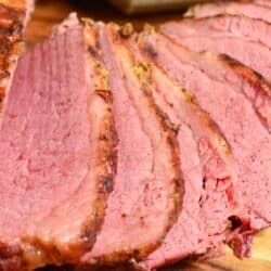 Instant pot corned beef cooked and with several slices on a cutting board.