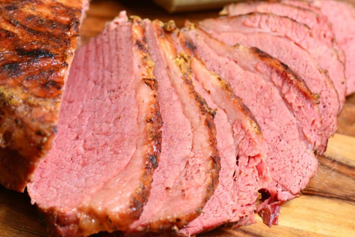 Instant pot corned beef cooked and with several slices on a cutting board.