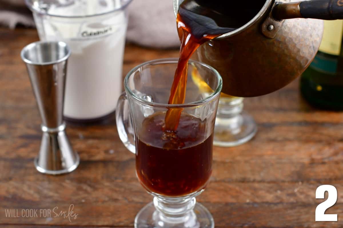 Pouring coffee into the glass with the whiskey for the Irish coffee.