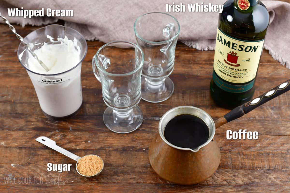 Labled ingredients for Irish Coffee on a wood surface.