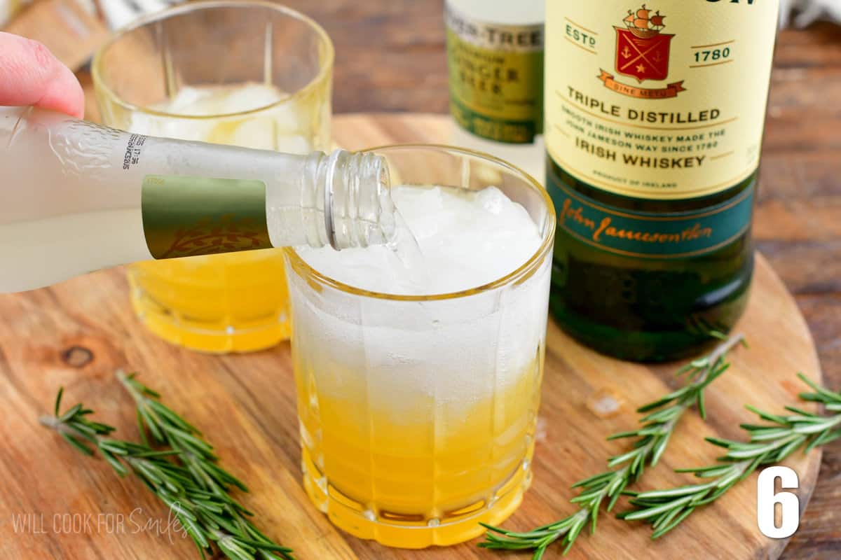 adding ginger beer into the glass of Irish lemonade.