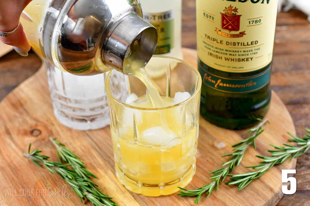 pouring the irish lemonade mixture into a glass with ice.