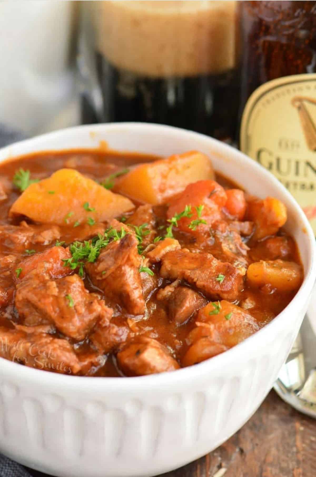 Irish beef stew in a bowl on a wood surface.