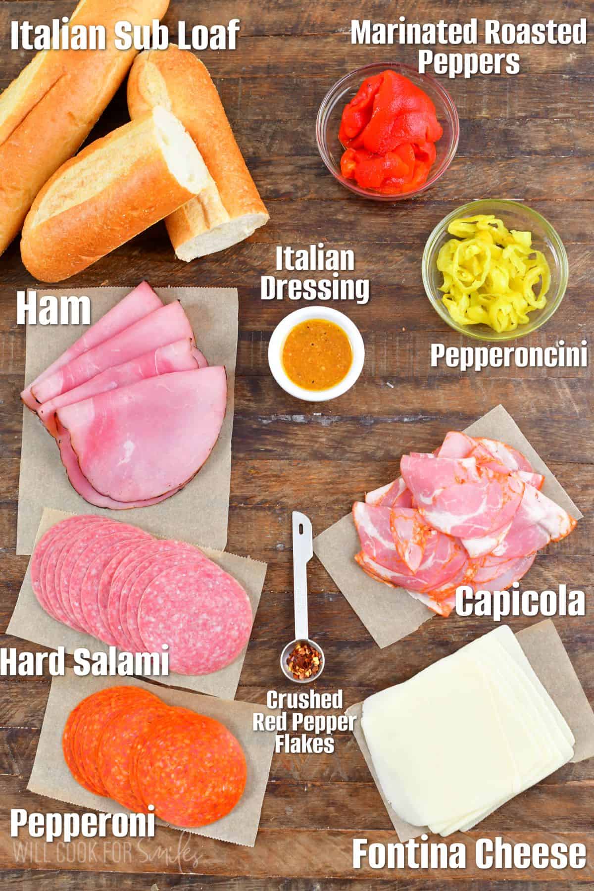 Labeled ingredients for Italian sub on a wood surface.