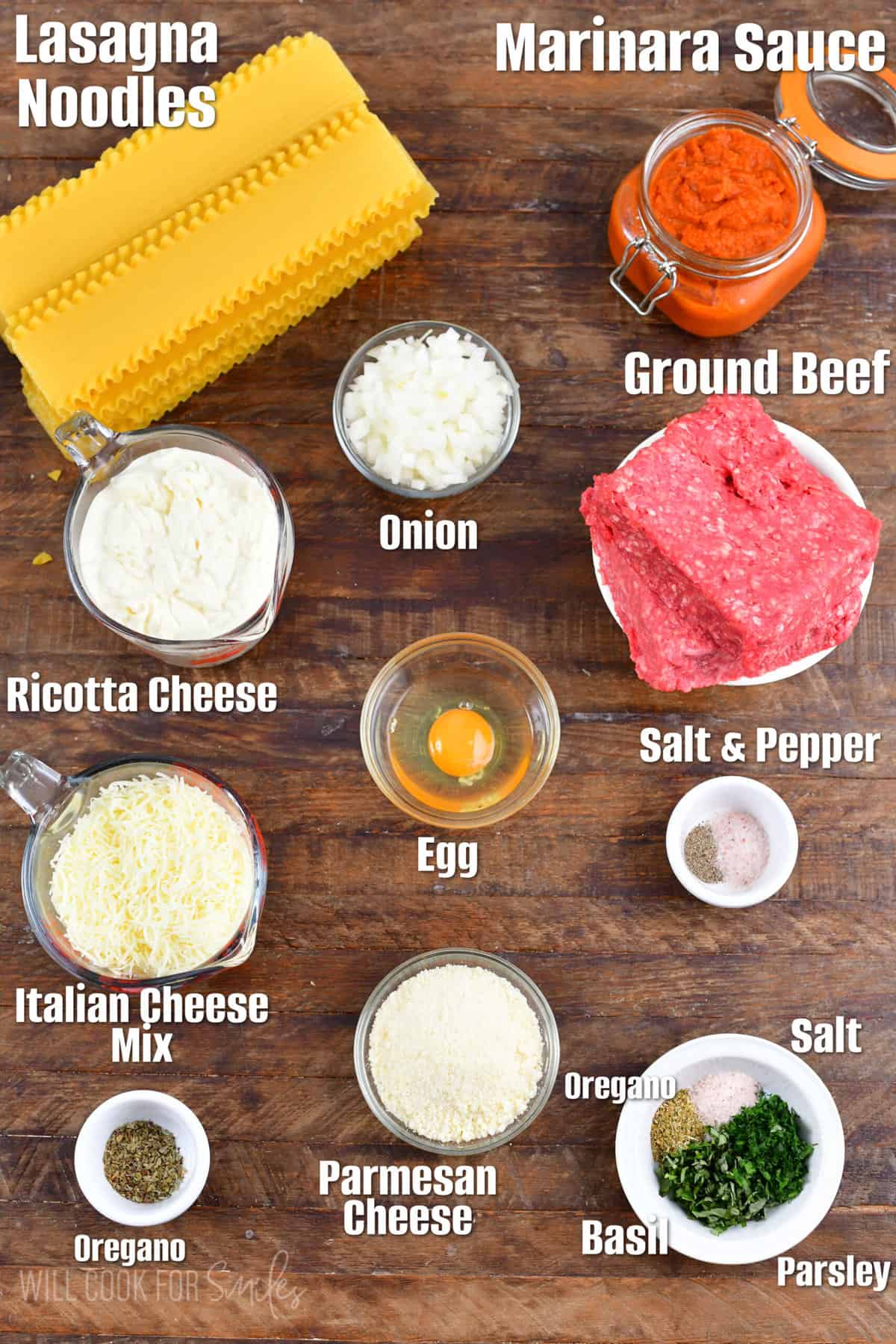 Labeled ingredients for lasagna on a wood surface.