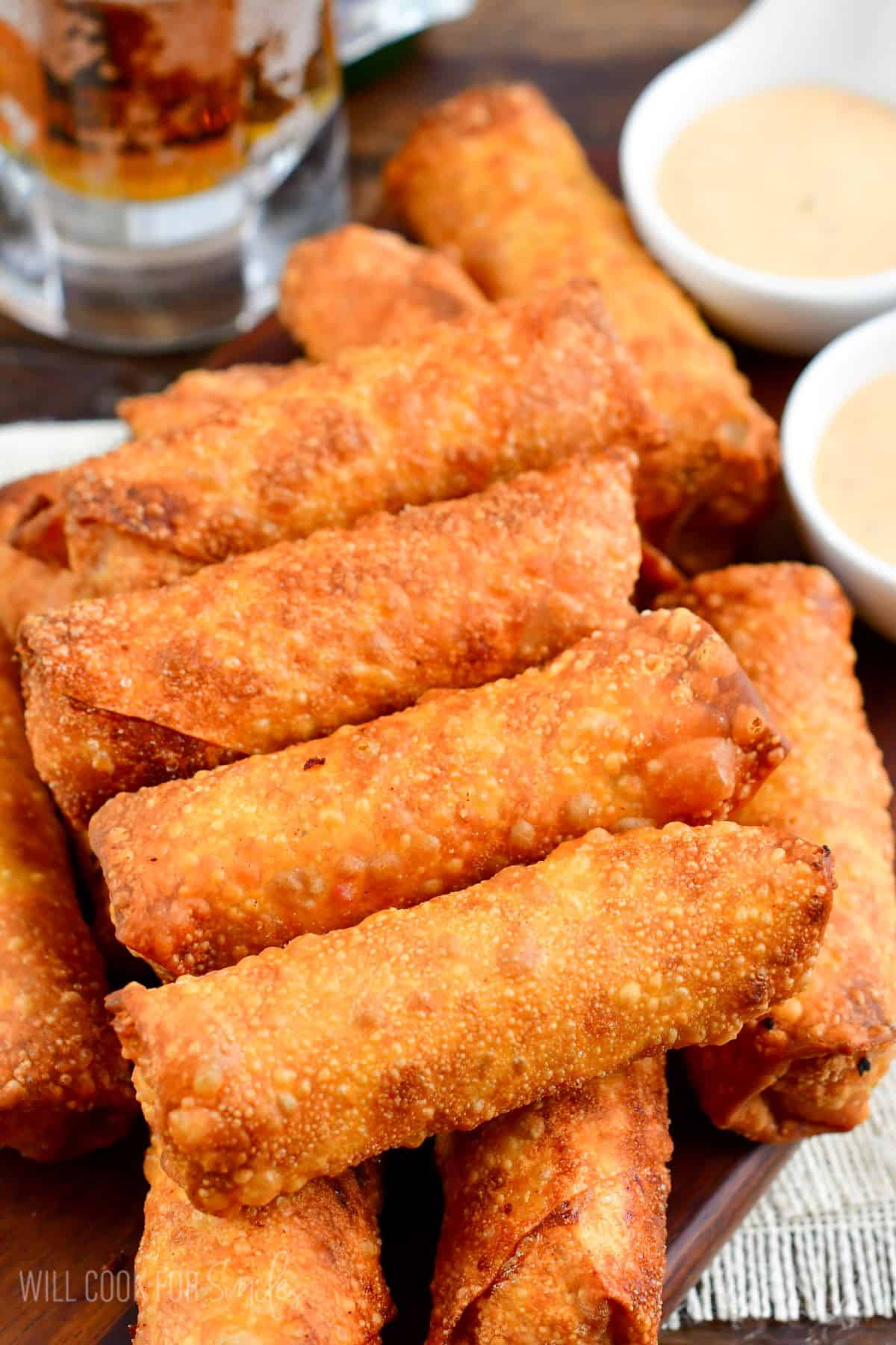 Stacked Reuben egg rolls on a tray.