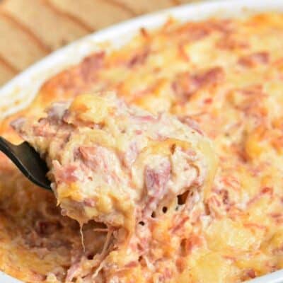 Scooping up some of the Reuben dip with a fork out of the baking dish.