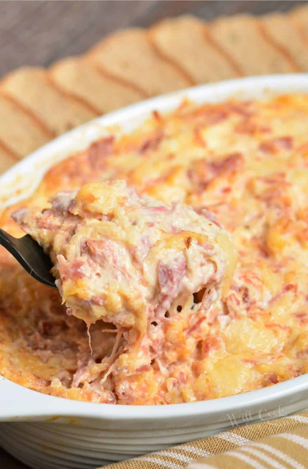 Scooping up some of the Reuben dip with a fork out of the baking dish.