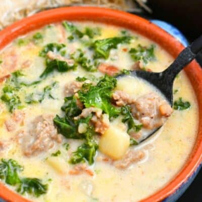 Zuppa Toscana soup in a bowl with a spoon scooping some out.