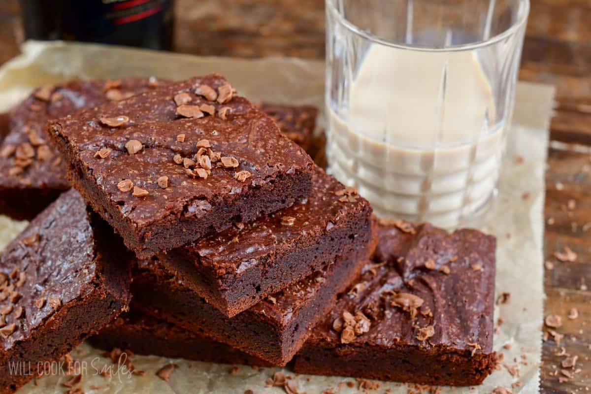 brownies fanned out on parchment paper with a glass of baileys to the side.