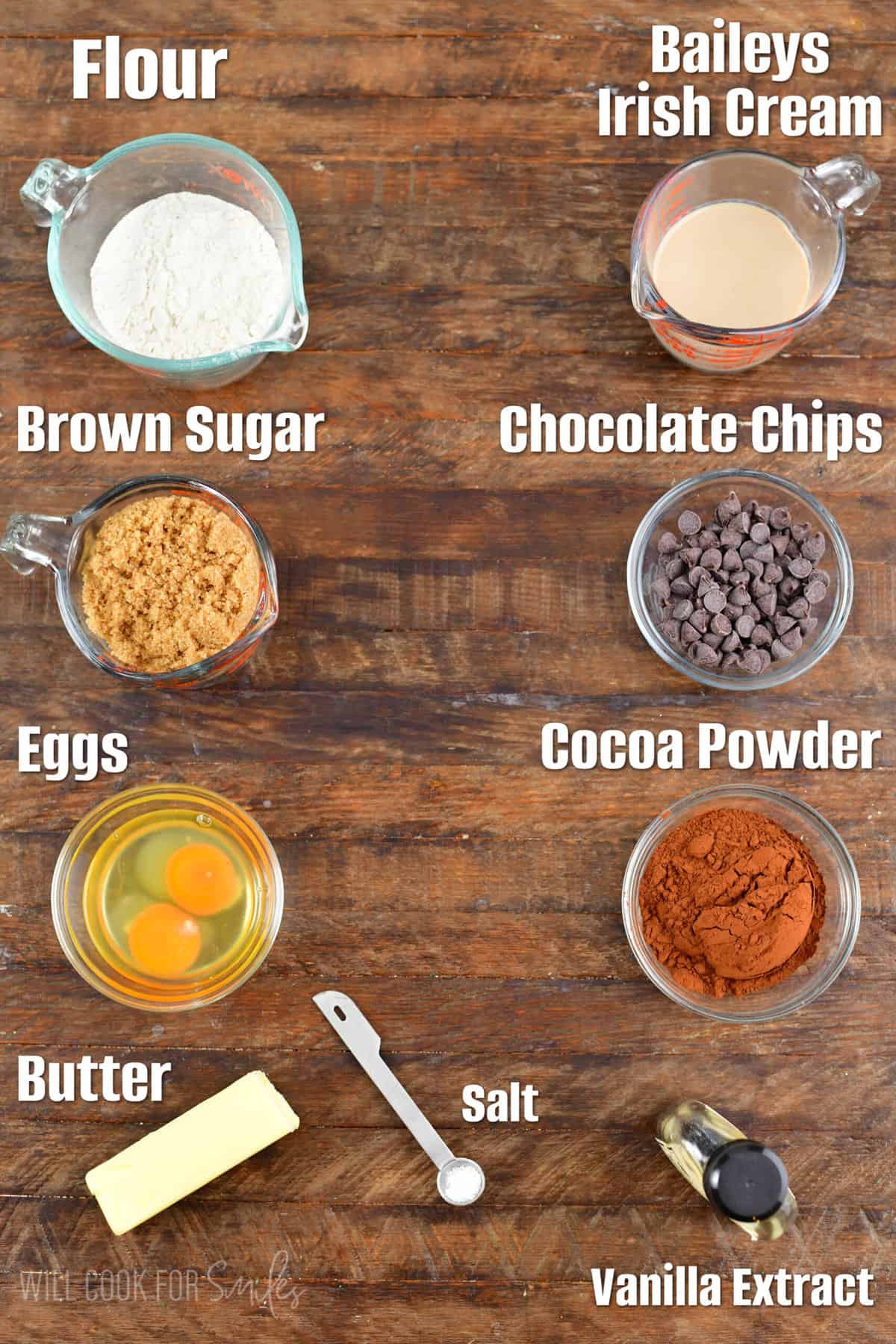 Labeled ingredients for Baileys Brownies on a wood surface.