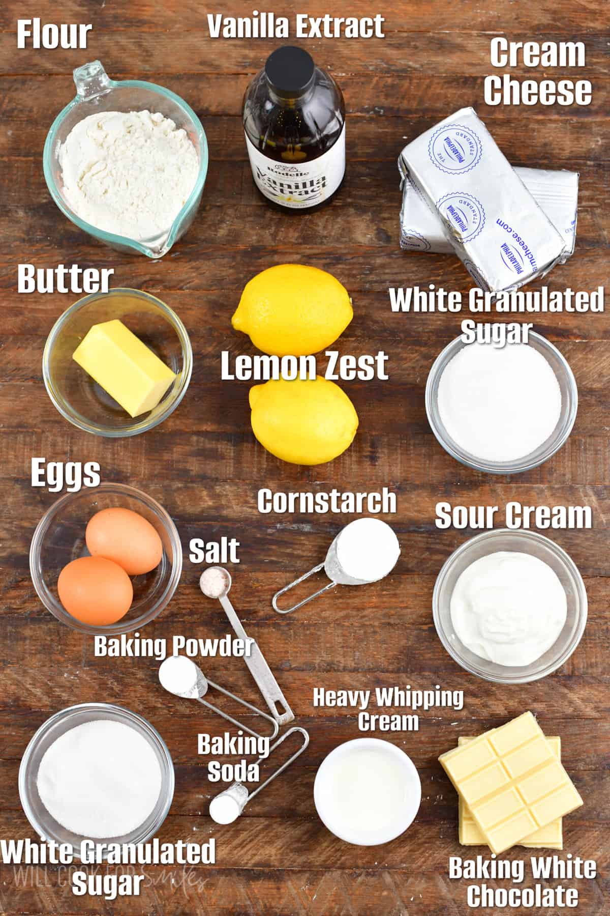 Labeled ingredients for lemon cheesecake cookie bars on a wood surface.