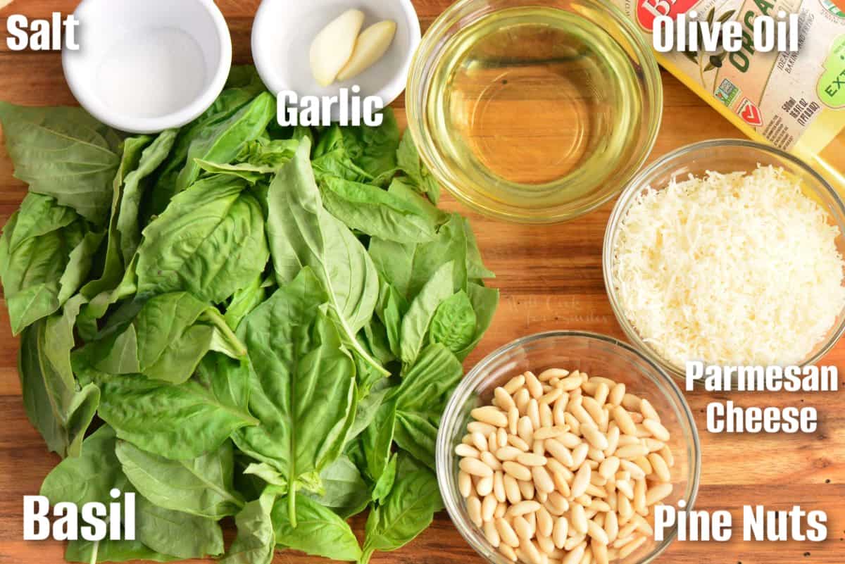 labeled ingredients to make basil pesto on the cutting board.