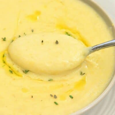 Potato leek soup in a bowl with a spoon scooping some up.