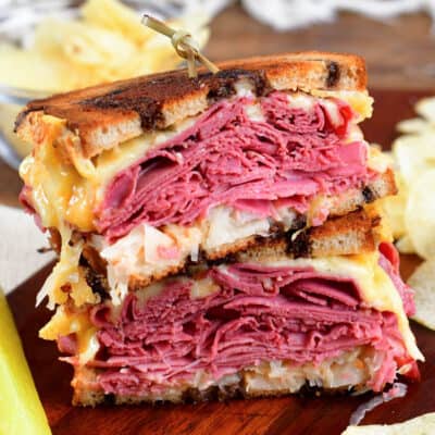 Warm Reuben sandwich cut in half stacked on top of each other.