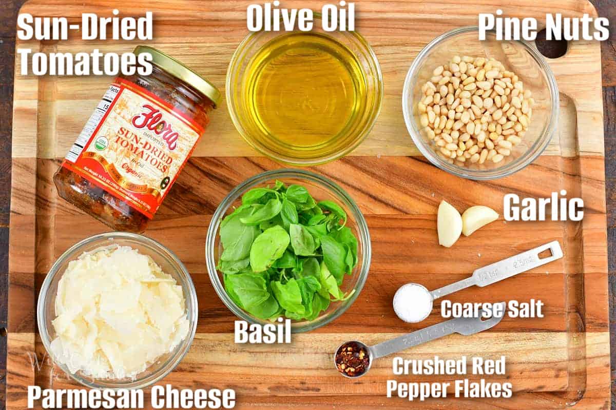 labeled ingredients to make sub dried tomato pesto aka pesto rosso on a cutting board.