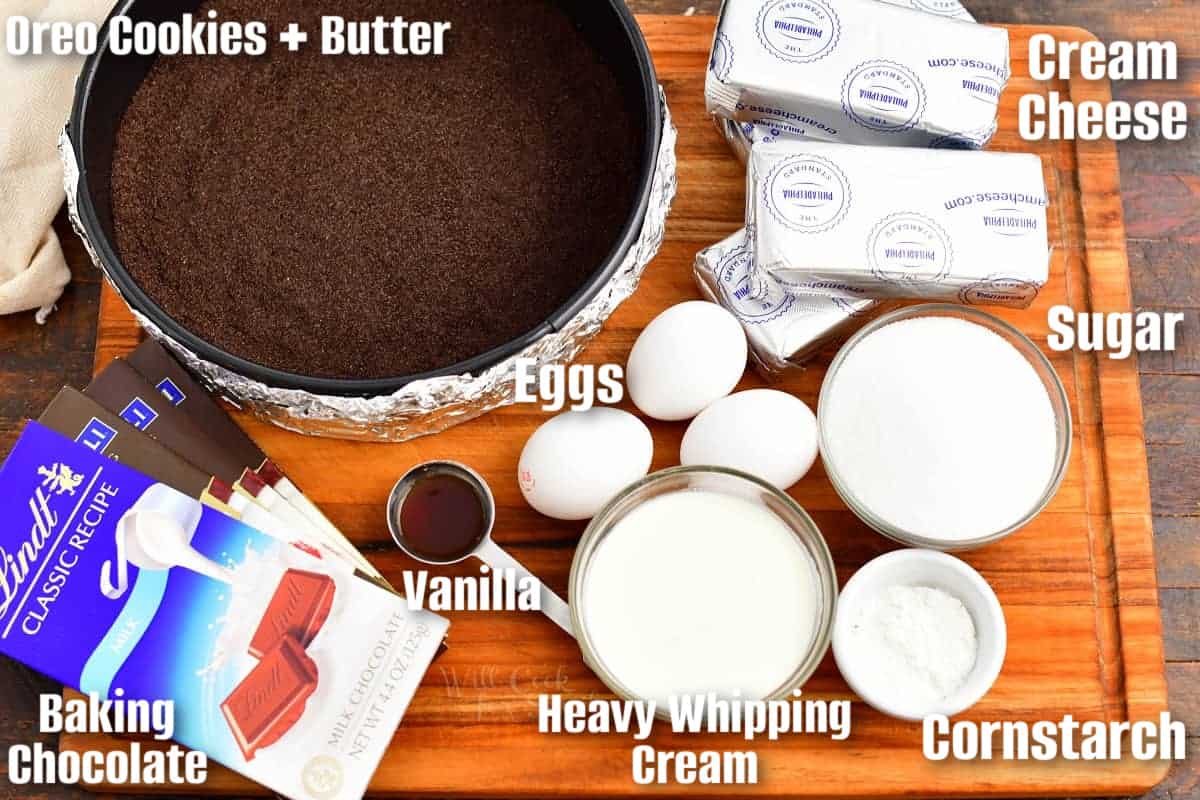 labeled ingredients to make chocolate cheesecake on a cutting board.