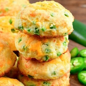 Stack of four jalapeno cheddar biscuits on a cutting board.