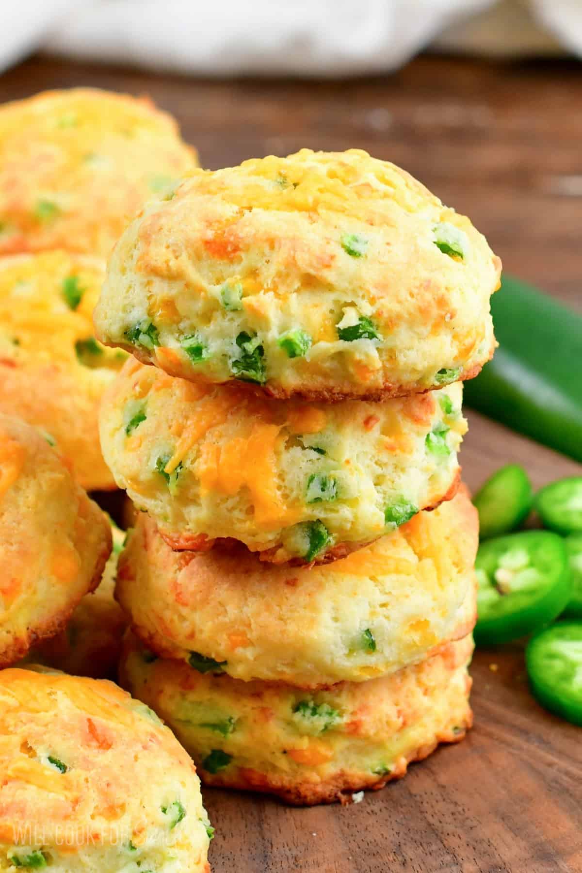 Stack of four jalapeno cheddar biscuits on a cutting board.