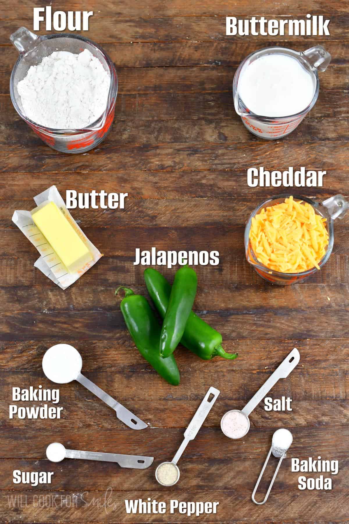 Labeled ingredients for Jalapeno Cheddar Buttermilk biscuits on a wood surface.